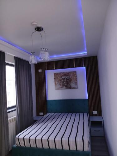 a bedroom with a bed with a picture on the wall at Apartament Matthias in Mangalia