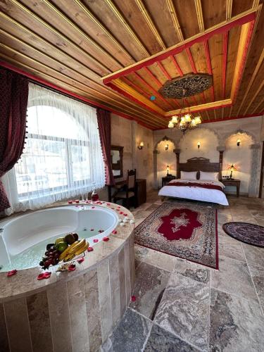 a large room with a tub and a bed at Hasan Bey Konakları in Avanos