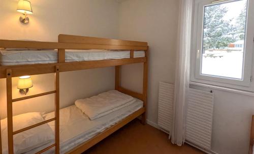 a bunk bed room with two bunk beds and a window at Résidence Vacancéole Les Monts Jura in Lélex