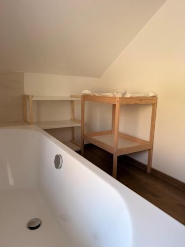 a white bath tub with a wooden shelf in a bathroom at Moulin de Baillonville in Baillonville