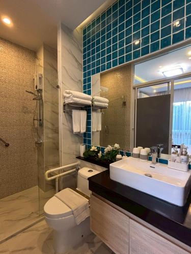 a bathroom with a sink and a toilet and a mirror at Deco Harmony Pattaya 1 in North Pattaya