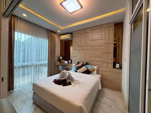 a bedroom with a large bed and a large window at Deco Harmony Pattaya 1 in North Pattaya