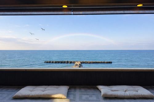 a view of the ocean from a window with pillows at Moonbay Beach Villa in Lake Toya