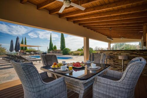 a patio with a table and chairs and a pool at Casa Rosa - Heated Pool & Sea Views in Loulé