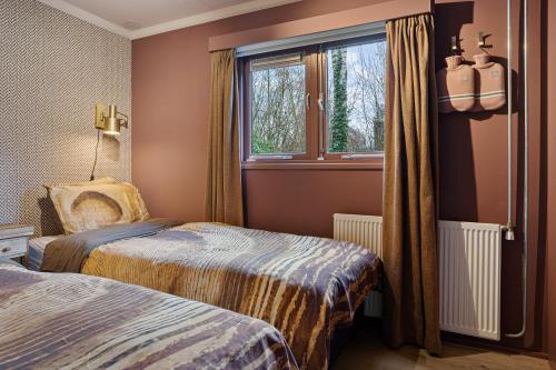 a hotel room with two beds and a window at Boshuisje met privétuin bij Kruisbergse bossen Achterhoek in Hummelo