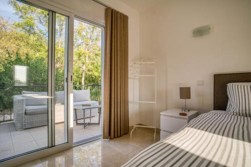 a bedroom with a bed and a sliding glass door at Casa Rosa - Heated Pool & Sea Views in Loulé