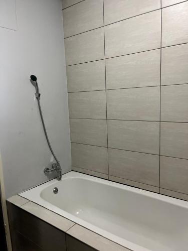 a bathroom with a bath tub with a shower at 51 Lazarett Loft & Car Rental in Windhoek