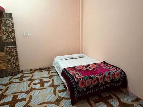 a small bedroom with a bed with a colorful blanket at New Giri Homestay in Nichlaul
