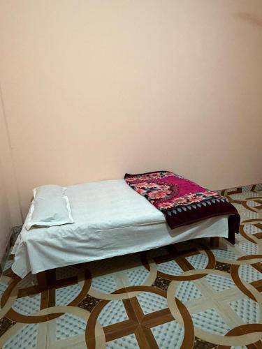 a bed in a room with a blanket on it at New Giri Homestay in Nichlaul