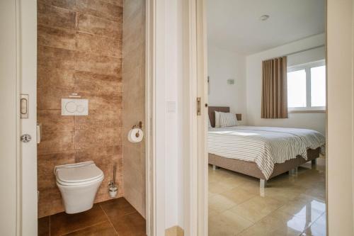 a bathroom with a bed and a toilet in a room at Casa Rosa - Heated Pool & Sea Views in Loulé