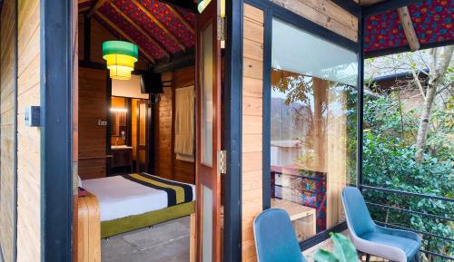 a room with a bed and two chairs on a balcony at O2 Villas Ella in Ella