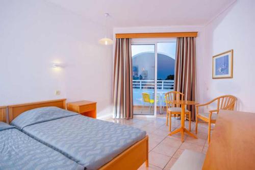a bedroom with a bed and a table and a dining room at Continental Palace in Psalidi