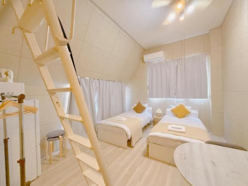 a room with two beds and a ladder at Mori house ookubobiru in Tokyo