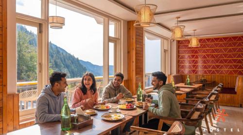 a group of people sitting at a table in a restaurant at Zostel Dharamkot, Bhagsu in McLeod Ganj