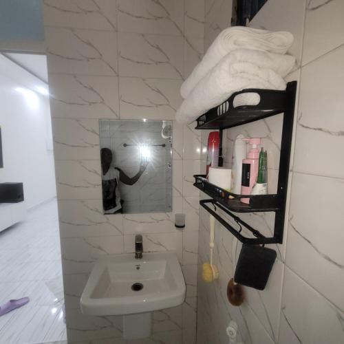 a bathroom with a sink and a mirror and towels at Mary homestays in Dar es Salaam