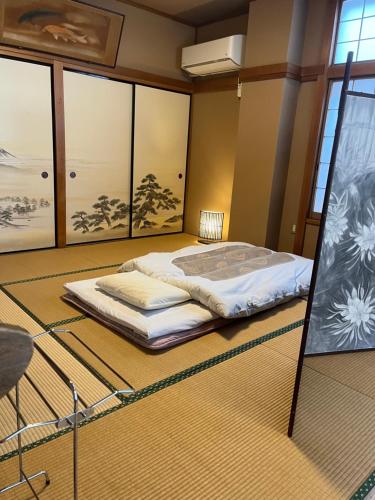 a bedroom with a bed in the middle of a room at 民話の宿荒澤屋旅館 Atasawaya Ryokkan, a inn of folk tales in Okutama