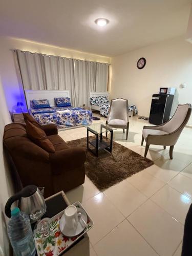 a living room with a couch and a bed and chairs at MAMA DELiGHT HOME in Abu Dhabi