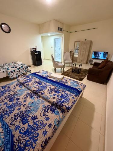 a bedroom with a bed with a blue and white blanket at MAMA DELiGHT HOME in Abu Dhabi