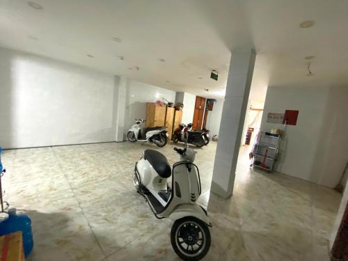 a scooter parked in a room with two motorcycles at LotusHotel 2 in Ho Chi Minh City