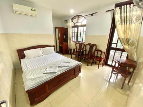 a bedroom with a bed and chairs in it at LotusHotel 2 in Ho Chi Minh City