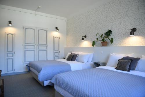 two beds in a room with white walls at Château de Fontager in Serves-sur-Rhône