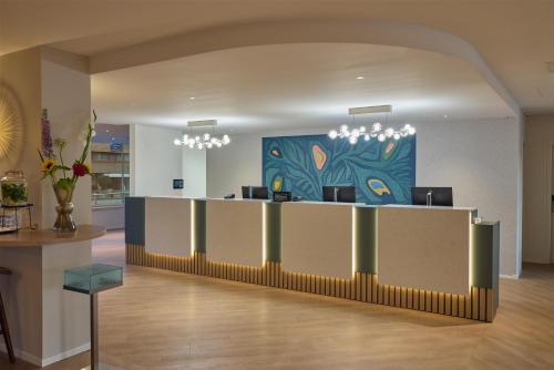 a lobby with a reception desk with a painting at DoubleTree by Hilton Rotterdam Centre in Rotterdam