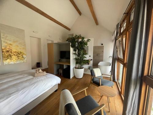 a bedroom with a bed and two chairs and a table at EBURON estate Boutique B&B in Diets-Heur