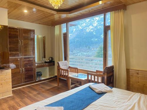 a bedroom with a bed and a large window at Liora Stays in Palchān