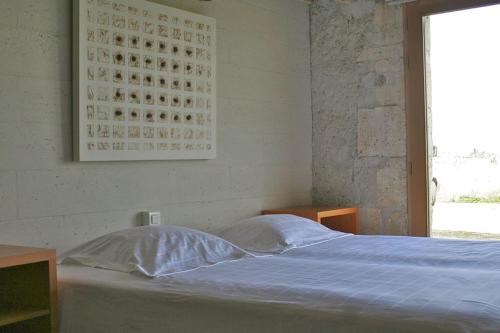 a bedroom with a bed with a blue sheets and a window at Les Renaudières Chalais in Chalais