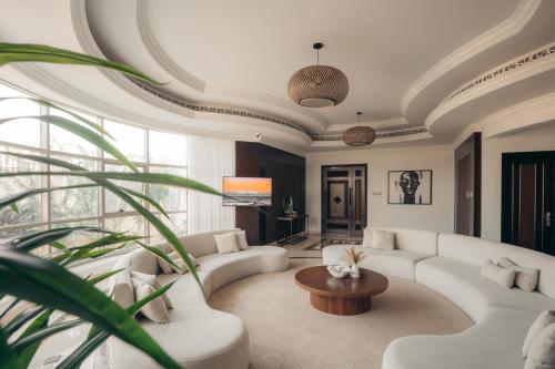 a living room with white couches and a table at Full Moon Guesthouse in Dubai