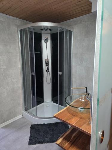 a bathroom with a shower with a glass table at NEUBEGINN b in Bad Rodach