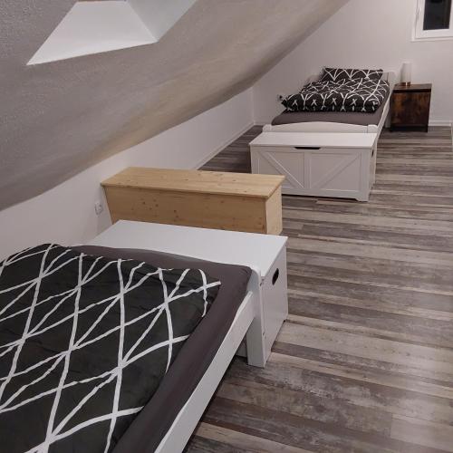 a bedroom with two beds and a staircase at NEUBEGINN b in Bad Rodach