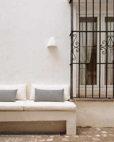 a white couch sitting in front of a building at Casa Teva Rooms Sevilla in Seville
