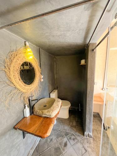 a bathroom with a toilet and a wooden table at Riad Atlas Surf in Tamraght Ouzdar