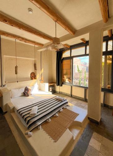 a bedroom with a large bed and a large window at Riad Atlas Surf in Tamraght Ouzdar
