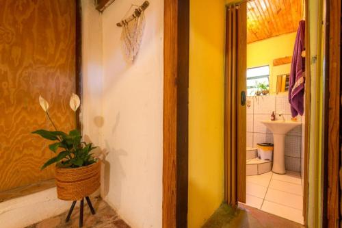 a bathroom with a toilet and a sink and a door at Hospedaria Quintal dos Sonhos in Vale do Capao