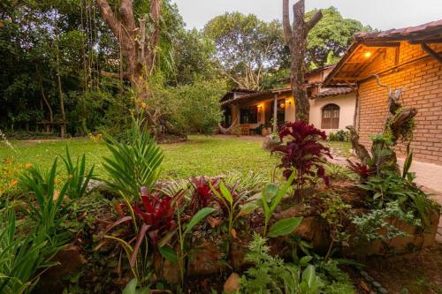 a garden in front of a house with flowers at Hospedaria Quintal dos Sonhos in Vale do Capao