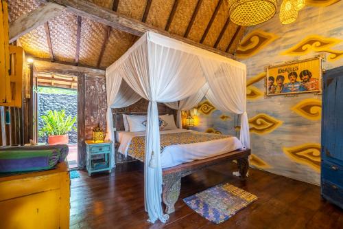 a bedroom with a canopy bed in a room at Kai's Beachfront Villa in Gili Islands