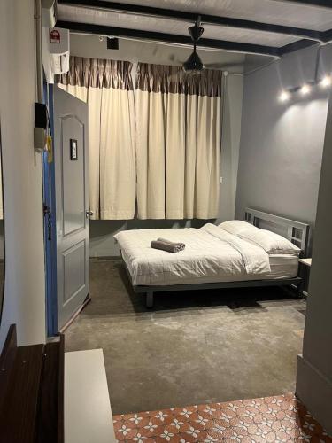 a bedroom with a bed and a window at Roomah En-suite attached-bath R6 in Ipoh