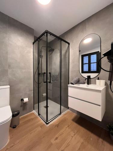 a bathroom with a glass shower and a sink at Terrazas de la Catedral III in Castellón de la Plana