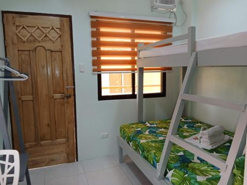 a bedroom with a bunk bed and a door at JAG Homes in Puerto Princesa City