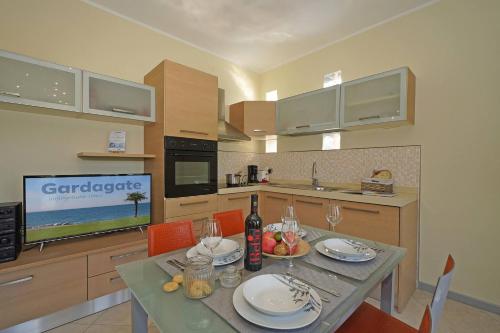 a kitchen with a table with plates and wine glasses at Apt Il Barcone - Gardagate in Sirmione