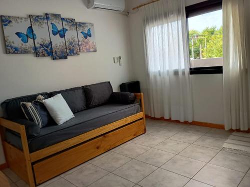 a couch in a living room with a window at Confort urbano - Departamento de 1 dormitorio con cochera in Venado Tuerto