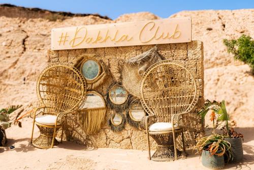 two wicker chairs and a sign on a wall at Hotel Dakhla Club & SPA in Dakhla