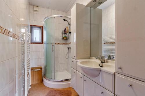 a white bathroom with a sink and a shower at De Bosparel in Doldersum