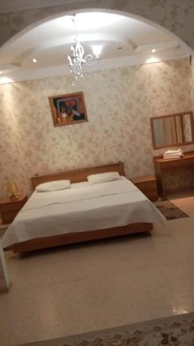 a bedroom with a bed and a chandelier at Delight Сая in Astana