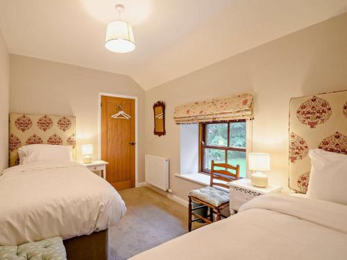 a bedroom with two beds and a window at 3 Bed in Lockerbie oc-89759 in Ecclefechan