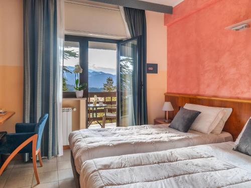 a bedroom with two beds and a large window at Cipriani Park Hotel in Rivisondoli