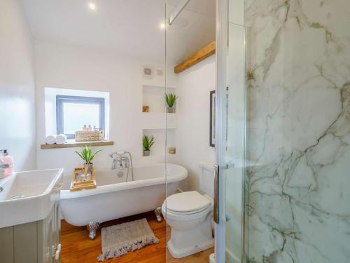 a bathroom with a tub and a toilet and a sink at 3 Bed in Colne oc-89582 in Colne