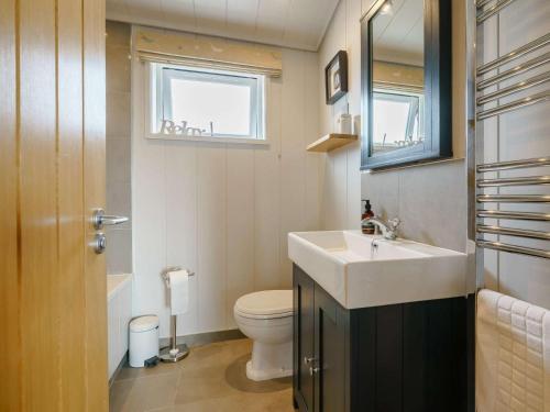 a bathroom with a sink and a toilet and a mirror at 3 Bed in St. Andrews oc-88545 in Balmullo